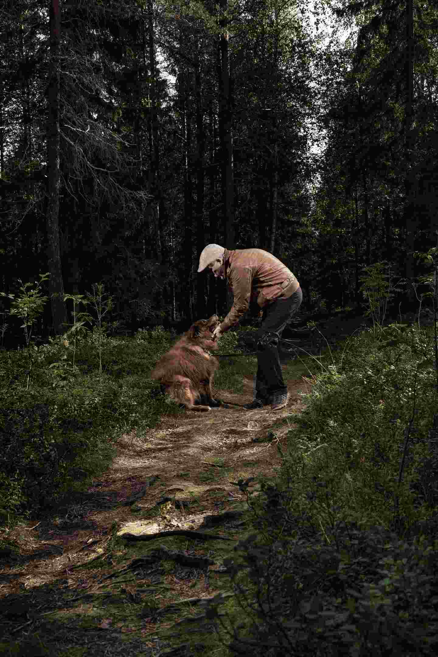 En person och en hund i skogen.