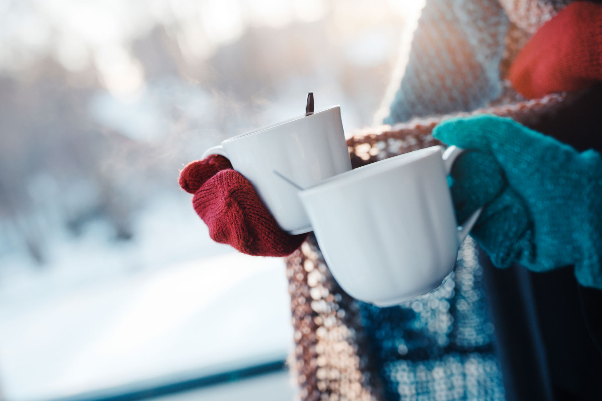 Två människor står ute med kaffekopp in handen.