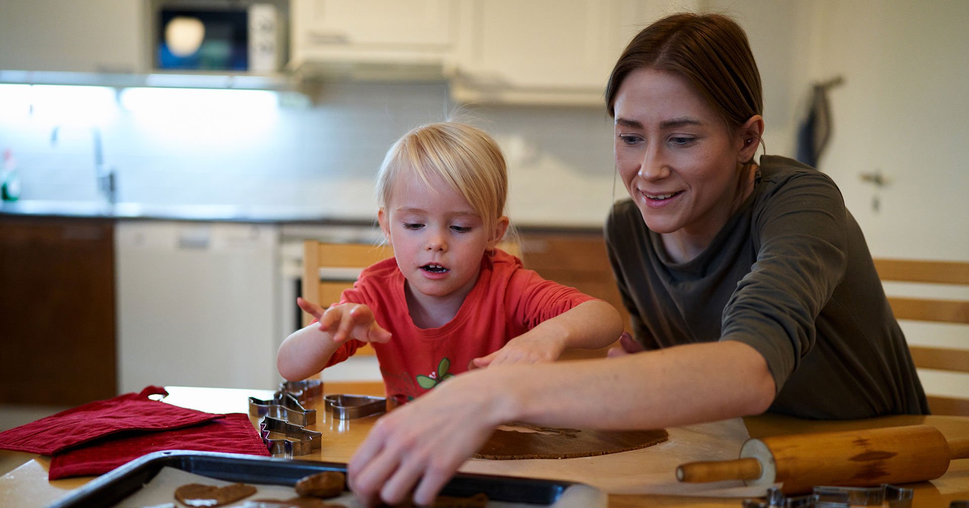 En vux och en barn bakar pepparkakor.