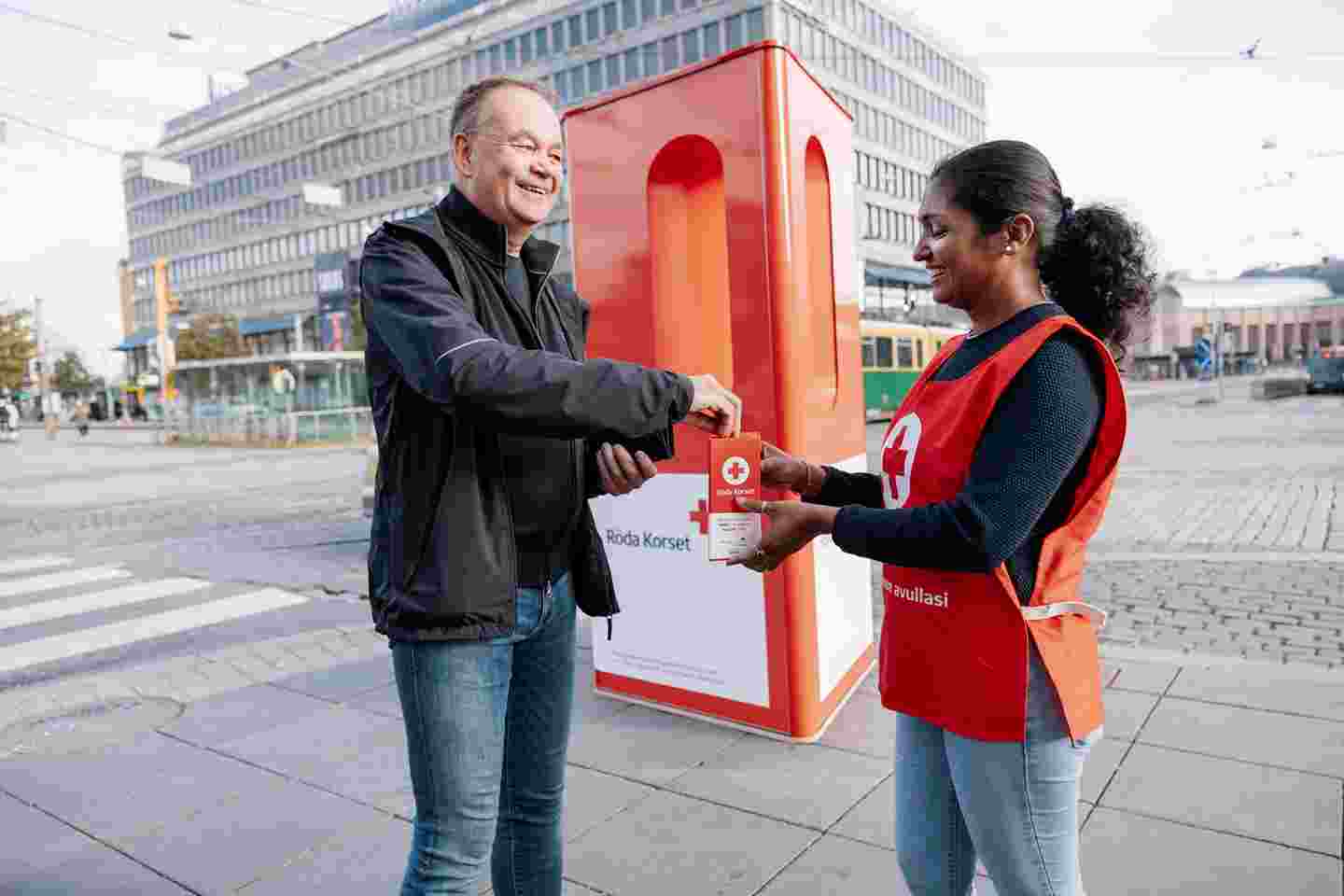 En människa donerar till Hungerdagsbössan.