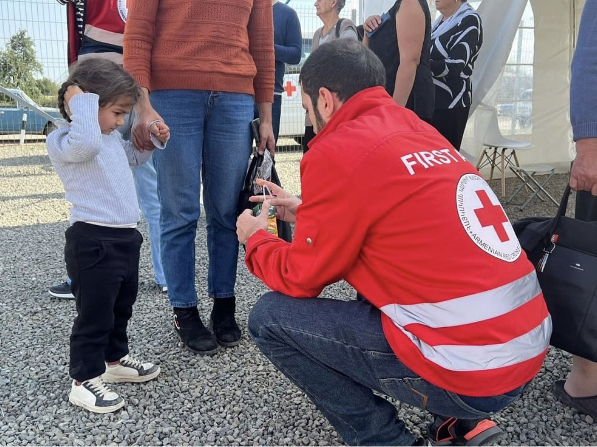 En frivillig från Armeniens Röda Korset hjälper ett barn.