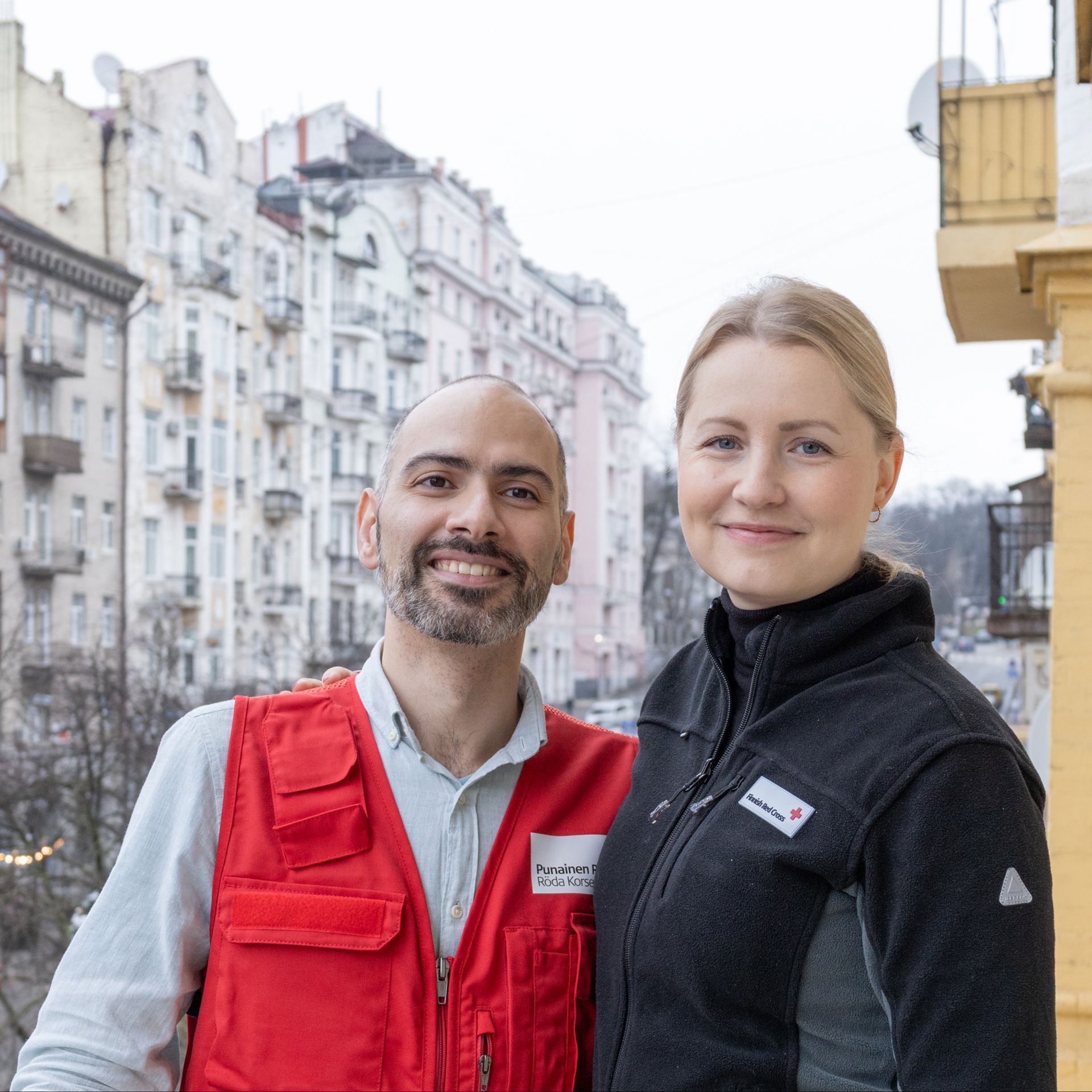 Vahram Vardanyan och Heidi Saarinen står leende i en stadsmiljö.