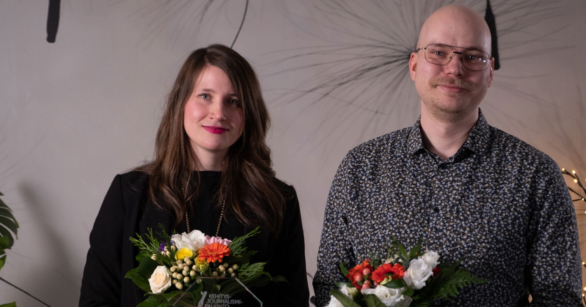 En man och en kvinna med blommorna i händerna.