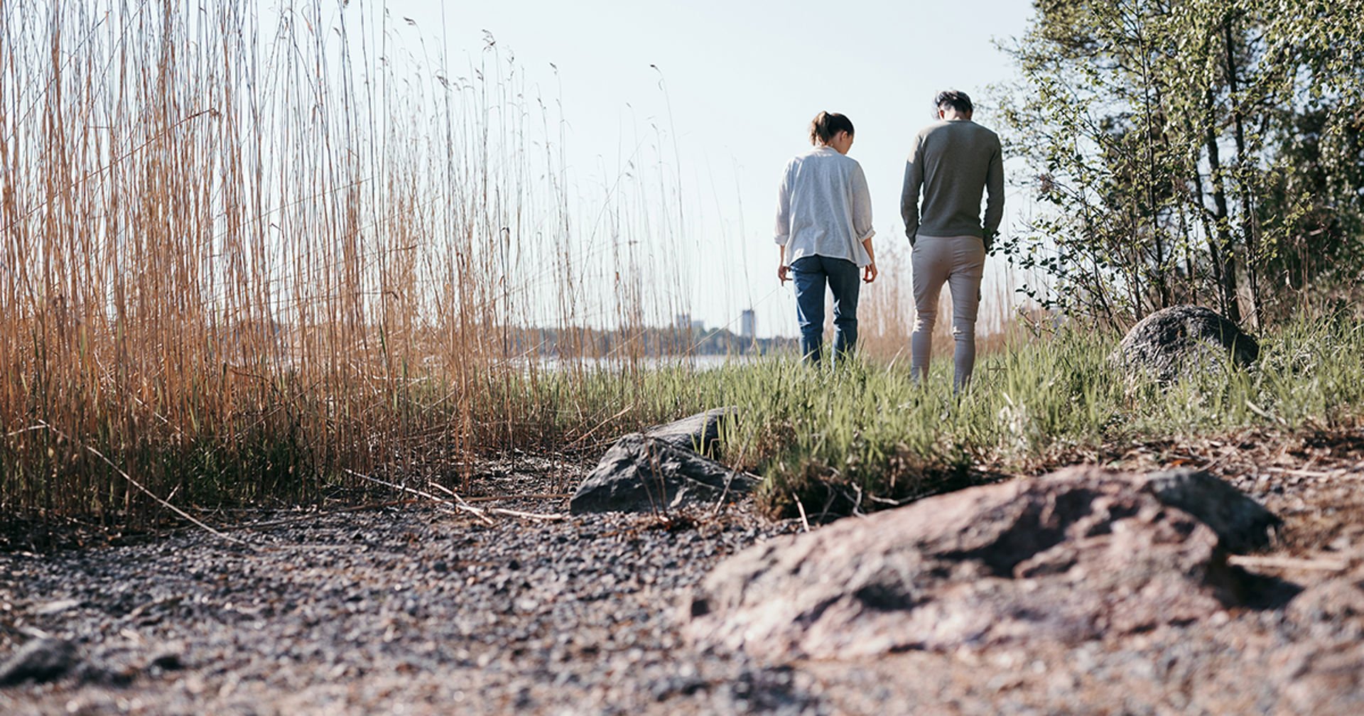 Två personer går och pratar på en strand.